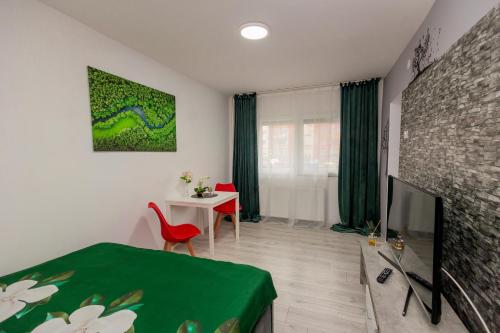 a living room with a bed and a tv and a table at Urban Escape Arad in Arad