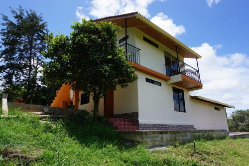 a house with a tree in front of it at Campo y Descanso 15 min Ciudad in Popayan