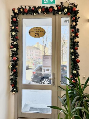 a door with a christmasreath and a sign on it at Pension am Wienfluss in Vienna