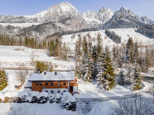 a house in the snow with mountains in the background at Haus Weissbach in Griessen