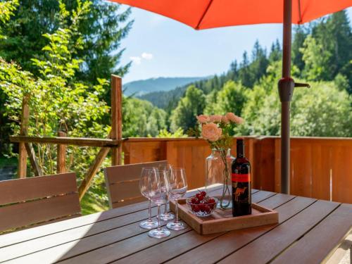 a wooden table with wine glasses and an umbrella at Haus Weissbach in Griessen