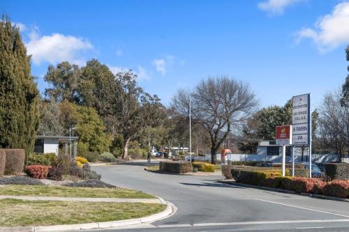 an empty road with a sign in the middle at Southside Village in Canberra