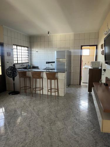 a kitchen with a counter and stools in it at Apartamento Aconchegante Centro! in Alfenas