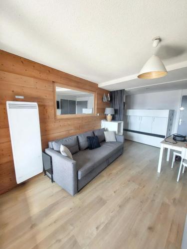 un salon avec un canapé et une table dans l'établissement Appartement cosy à L'Alpe d'Huez 27 m² avec vue montagne, à L'Alpe-d'Huez