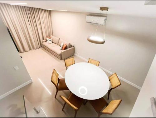 a living room with a table and chairs and a couch at Cobertura Sol Sereno in Cabo Frio