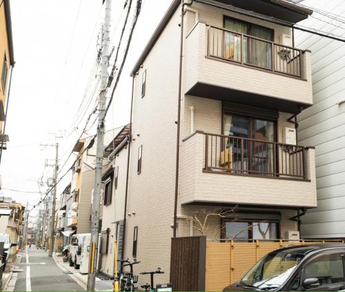 a building with balconies on a city street at YADO TENKU Kyoto Nijo in Kyoto