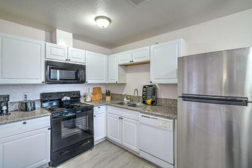 a kitchen with white cabinets and a stainless steel refrigerator at Your Vegas Home From Home! Sleeps 6! in Las Vegas