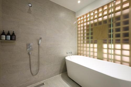 a bathroom with a bath tub and a shower at TRT Hotel in Busan