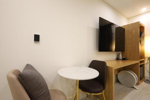 a room with a table and two chairs and a desk at TRT Hotel in Busan
