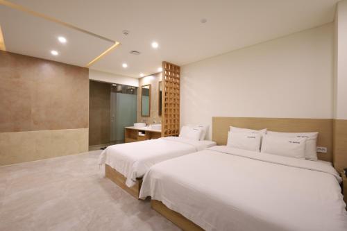 a hotel room with two beds and a bathroom at TRT Hotel in Busan