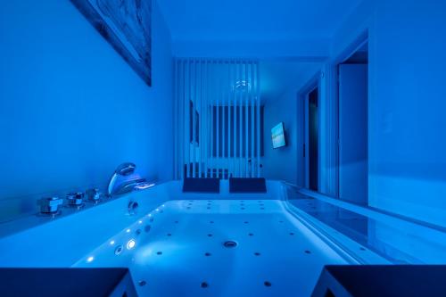 a bath tub with blue lights in a bathroom at PREMIUM JACUZZI SUITE at the City center, by Aqua Platinum in Thessaloniki