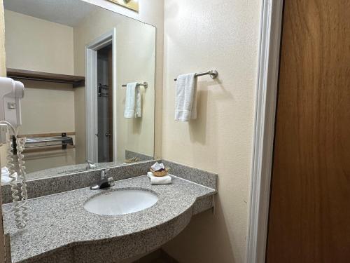 ein Badezimmer mit Waschbecken und Spiegel in der Unterkunft Regal Inn Las Vegas New Mexico in Las Vegas