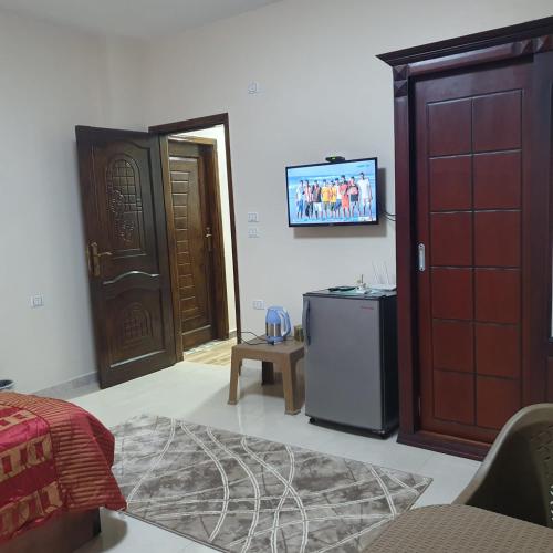 a living room with a door and a tv on the wall at Zein Pyramids View - Guest House in Cairo
