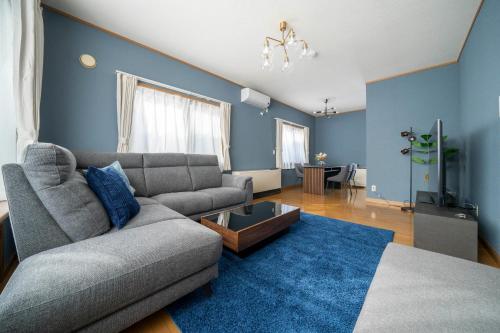 a living room with a couch and a blue wall at Torenia in Furano