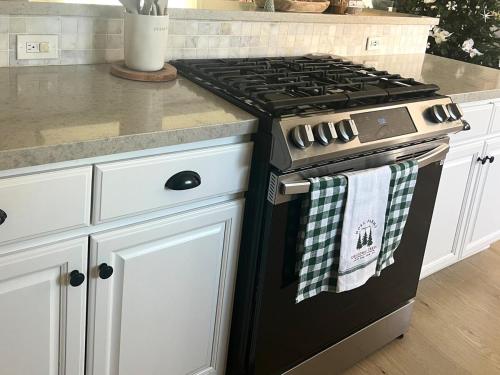 a kitchen with a black stove and white cabinets at Luxury Home LA Big Bear & LV 5 Mins to Mall in Victorville