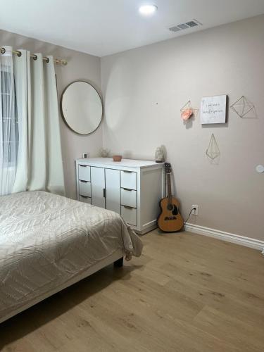a bedroom with a bed and a mirror and a guitar at Luxury Home LA Big Bear & LV 5 Mins to Mall in Victorville