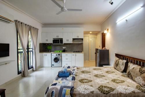 a living room with a bed and a kitchen at Dream key suits in Siolim