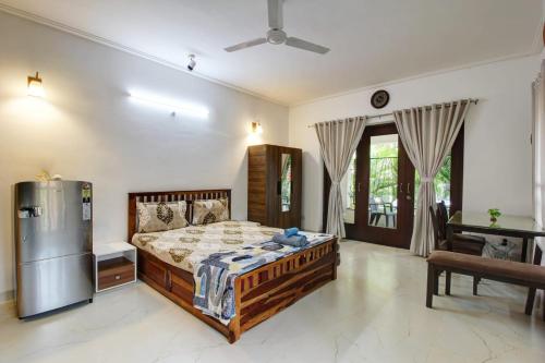 a bedroom with a bed and a refrigerator at Dream key suits in Siolim