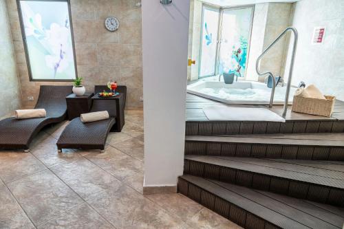 a bathroom with a bath tub and a table and chairs at Four Points by Sheraton Medellín in Medellín