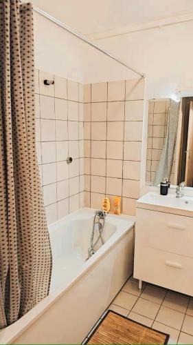 une salle de bain blanche avec une baignoire et un lavabo dans l'établissement Magnifique appartement cosy 3P à Chaville, à Chaville
