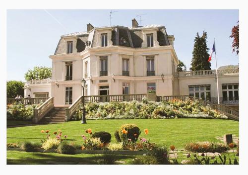 a large white house with a garden in front of it at Magnifique appartement cosy 3P à Chaville in Chaville