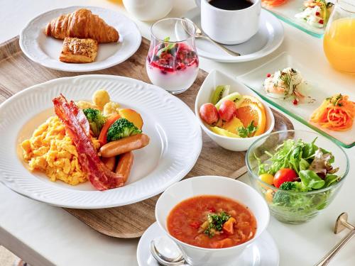 a table with plates of breakfast food on it at Hotel Grand Tiara Minaminagoya in Anjo