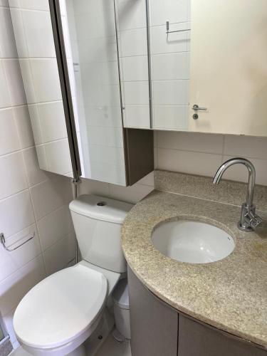 a bathroom with a white toilet and a sink at M&V Flats - Prédio Vision - 1,5 km Mané Garrincha - 500m Esplanada dos Ministérios - Vaga de garagem - Ar condicionado - Cama queen size - Piscina - Academia in Brasília