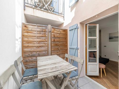 une table et des chaises en bois sur un balcon dans l'établissement Magnificent renovated 2 bedroom apartment, Terrace, à Cannes
