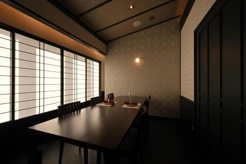 a dining room with a table and some windows at Hotel Grand Tiara Minaminagoya in Anjo