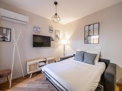 une chambre avec un lit et une télévision à écran plat dans l'établissement Renovated Cozy Apartment in Cannes Meynadier, à Cannes