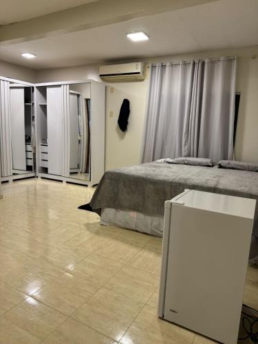a bedroom with a bed and a table in it at Chácara Aconchegante para COP 30 in Belém