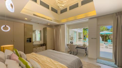 une chambre avec un lit et une cuisine avec une table dans l'établissement Beachfront Luxury villa near Banyan Tree, à Layan Beach