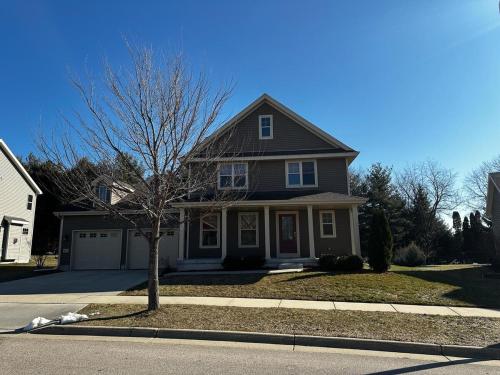 a house with a tree in the front yard at Unique World Homes in Madison