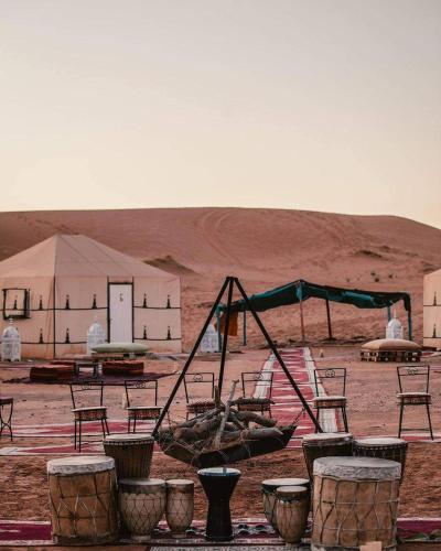 a group of chairs and a swing set in the desert at Erg Chebbi Star Camp in Merzouga