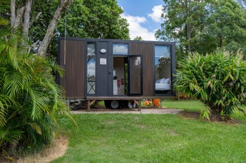 a tiny house is sitting in a yard at Chain of Ponds Cottage by Tiny Away in Tamaree