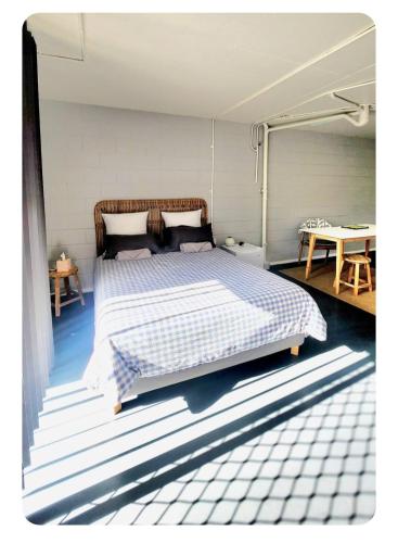 a bedroom with a bed with a blue and white bedspread at Detached Living Space in Rainbow Bay in Tweed Heads