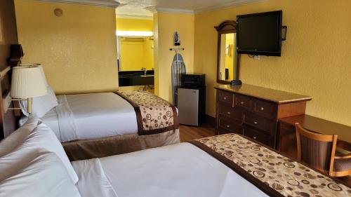 a hotel room with two beds and a flat screen tv at Americas Best Value Inn Frost Bank Center in San Antonio