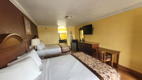 a hotel room with two beds and a desk at Americas Best Value Inn Frost Bank Center in San Antonio