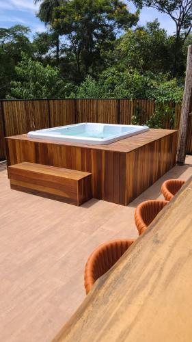 a hot tub in a deck with a wooden fence at Casas 3 Encantos in Santana do Riacho
