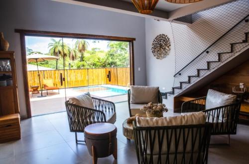 a living room with a table and chairs and a pool at Casas 3 Encantos in Santana do Riacho