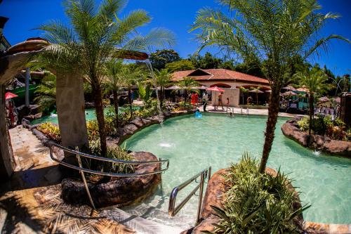 a pool at a resort with palm trees at Tauá Hotel & Convention Caeté in Caeté