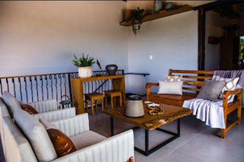 a living room with couches and a table at Casas 3 Encantos in Santana do Riacho