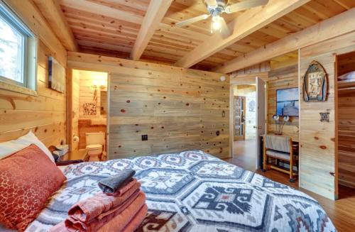 Un dormitorio con una cama en una cabaña de troncos en Modern Family Cabin with Deck, BBQ, Views and Playroom, en Duck Creek Village