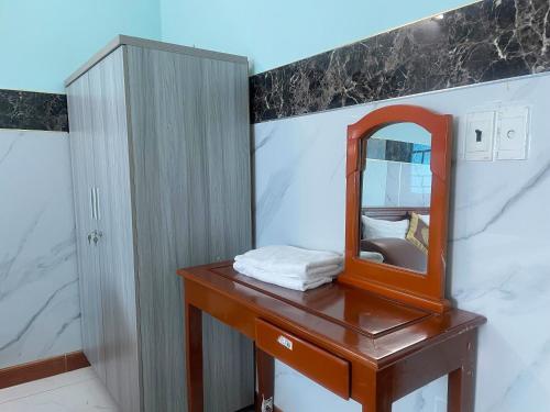 a bathroom with a wooden table with a mirror at Bien Sao Hotel in Ho Chi Minh City