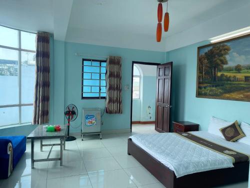 a bedroom with blue walls and a bed and a table at Bien Sao Hotel in Ho Chi Minh City