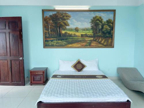 a bed in a room with a painting on the wall at Bien Sao Hotel in Ho Chi Minh City