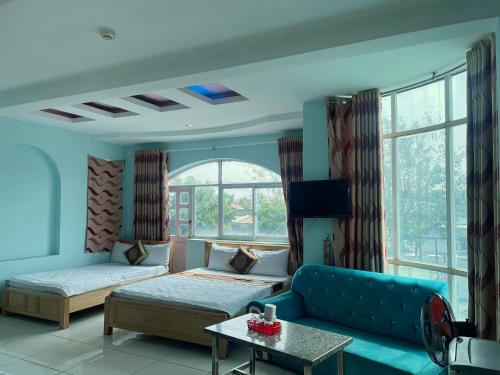 a living room with a blue couch and a table at Bien Sao Hotel in Ho Chi Minh City
