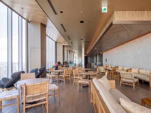 a restaurant with tables and chairs and windows at SAPPORO HOTEL by GRANBELL in Sapporo