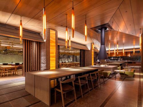 a restaurant with a bar with chairs and tables at SAPPORO HOTEL by GRANBELL in Sapporo