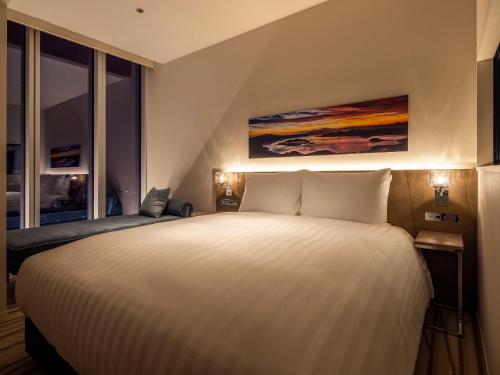 a bedroom with a large white bed and a window at SAPPORO HOTEL by GRANBELL in Sapporo